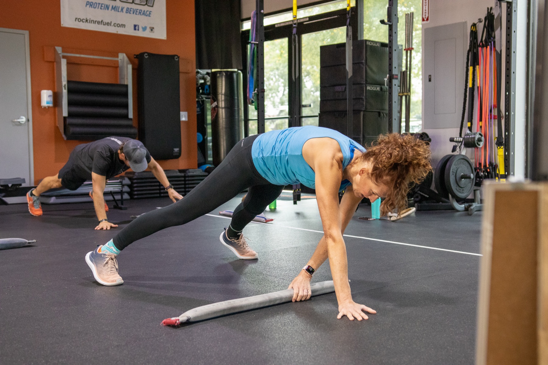 A member moving through a crawl pattern on the gym floor