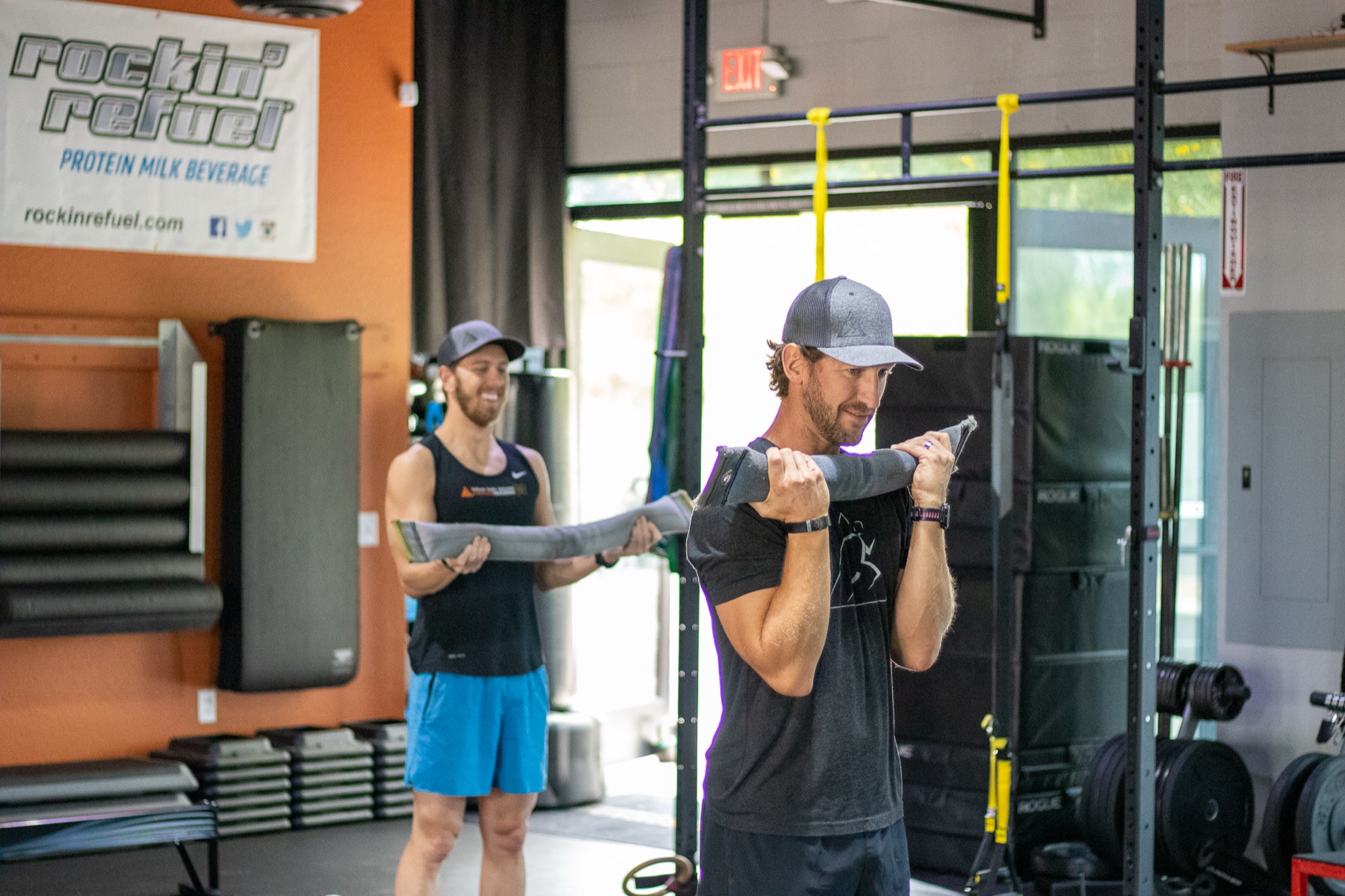 Two coaches demonstrating a cable exercise
