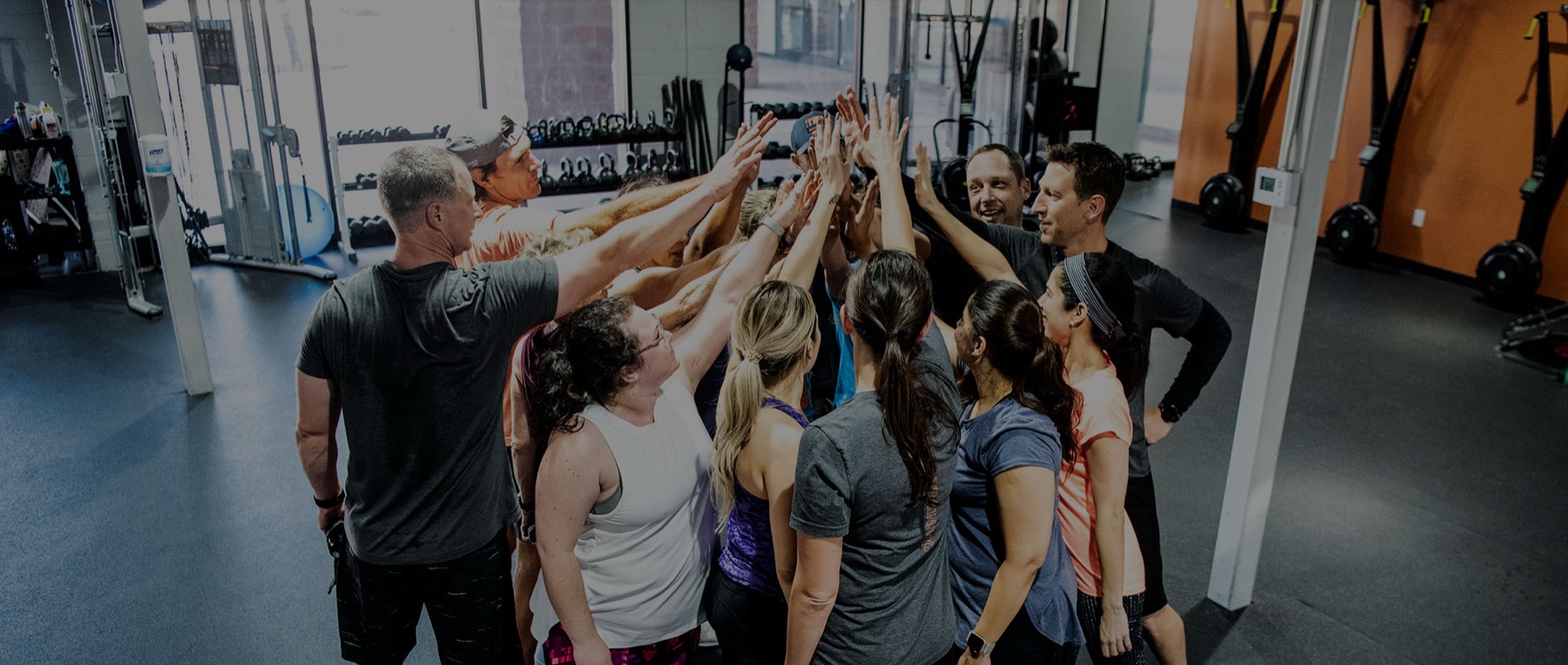 Triplex members and coaches in a team huddle after a workout